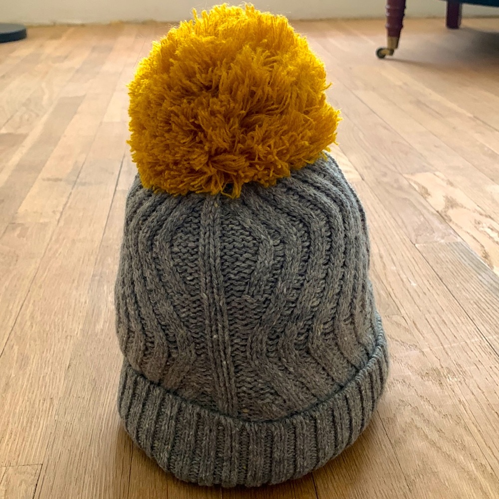 Women’s lined beanie with mustard colored pom pom